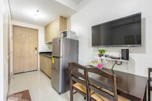 a kitchen with a stainless steel refrigerator and a table at Cozy 619 1BR Shore2 Residence, Near Airport, IKEA, MOA, SMX, Pasay City, Manila in Manila