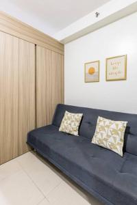 Sofá azul con 2 almohadas en una habitación en Cozy619 1BR at Shore 2 Tower 2 en Manila