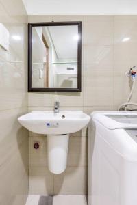 a white bathroom with a sink and a mirror at Cozy619 1BR at Shore 2 Tower 2 in Manila