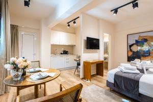 a room with a bed and a table and a kitchen at Villy's Comfort Zone Apartments in Kalamata