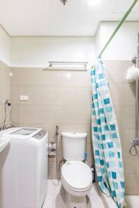 a bathroom with a toilet and a shower curtain at Cozy Staycation Shore 2 Residences Tower 2 in Manila