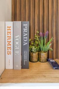 three books sitting on a shelf with potted plants at Cozy619 1BR at Shore 2 Tower 2 in Manila