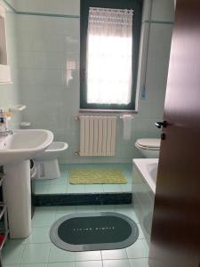 a bathroom with a sink and a toilet and a window at Appartement idéal pour découvrir le Sud d'Italie in Nova Siri Marina