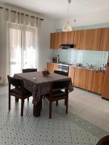 a kitchen with a table and some chairs and a table and a kitchen at Appartement idéal pour découvrir le Sud d'Italie in Nova Siri Marina