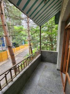 einen Balkon mit Blick auf eine Straße und Bäume in der Unterkunft King in Zaghkadsor