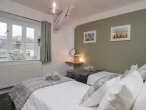 een slaapkamer met 2 bedden en een raam bij Ashwood Cottage in Grange Over Sands