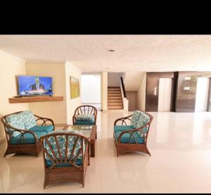 sala de estar con sillas, mesa y TV en Apartamento Rodadero, en Santa Marta