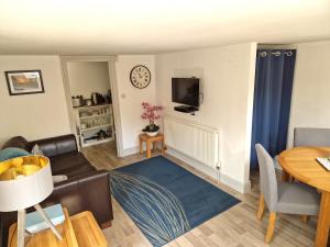 a living room with a couch and a table at The Coach House in Hawkhurst