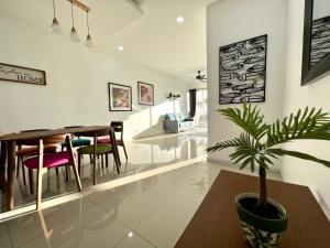une salle à manger et un salon avec une plante en pot dans l'établissement Home Away From Home In Taiping - Newly Upgraded!, à Taiping