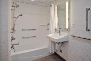 a white bathroom with a sink and a shower at Holiday Inn Express Kitty Hawk - Outer Banks, an IHG Hotel in Kitty Hawk