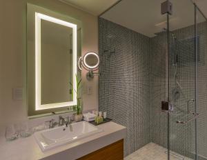 a bathroom with a sink and a shower with a mirror at The Westin Cozumel in Cozumel