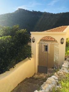 a door to a house with a mountain in the background at The Cove Assos in Asos