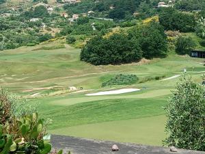 a view of a golf course with a green at Appartement Dans un Terrain de Golf, 5 min de la mer en Voiture, Parking Gratuit in Cogoleto