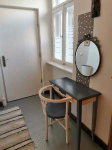 a black table and a chair and a mirror at Patrik apartman in Székesfehérvár