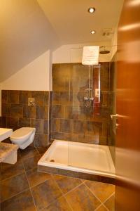 a bathroom with a bath tub and a toilet at Gästehaus Leimer Bräu in Lenzing