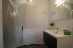 La salle de bains est pourvue d'un lavabo et d'une porte blanche. dans l'établissement Obiloua, à Orsanco