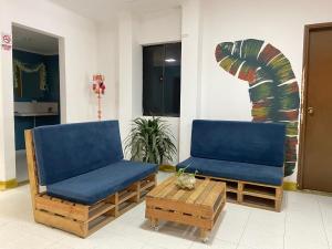 Duas cadeiras e uma mesa de centro num quarto em Hostal Baruch em Buritaca