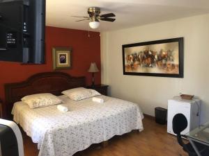Hotel Las Condes في تروخيو: غرفة نوم بسرير ودهان على الحائط