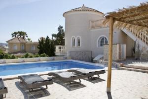 una piscina con sillas y una casa en Villa Torre, en El Campello