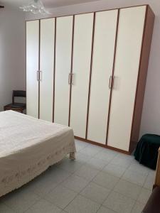 1 dormitorio con 1 cama y armario blanco grande en Appartement idéal pour découvrir le Sud d'Italie, en Nova Siri Marina