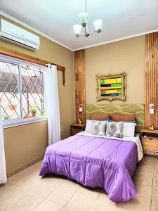um quarto com uma cama roxa e uma janela em Jazmines Apart em Martínez