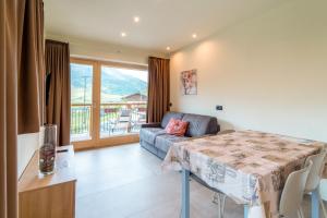 a living room with a table and a couch at Arion Apartments - Trepalle in Livigno