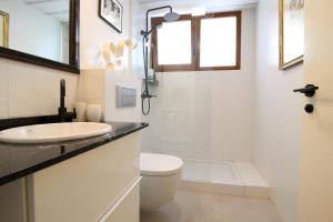 Luxury villa in El Sardinero في سانتاندير: حمام أبيض مع حوض ومرحاض