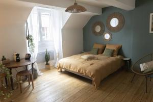 a bedroom with a bed and a table and mirrors at Charmant cocon centre historique in Besançon
