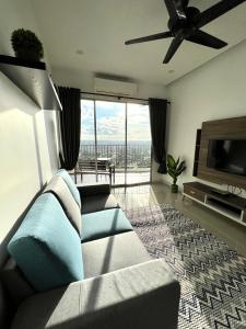 uma sala de estar com um sofá e uma televisão de ecrã plano em Home Away From Home In Taiping - Newly Upgraded! em Taiping