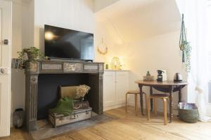 a living room with a fireplace with a television on top at Charmant cocon centre historique in Besançon