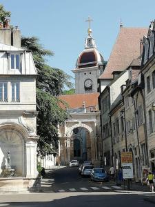 een oud gebouw met een klokkentoren in een stad bij Charmant cocon centre historique in Besançon