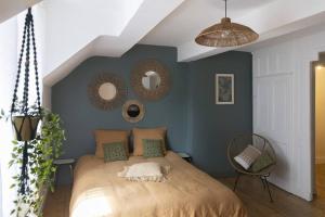 a bedroom with a large bed with two mirrors on the wall at Charmant cocon centre historique in Besançon
