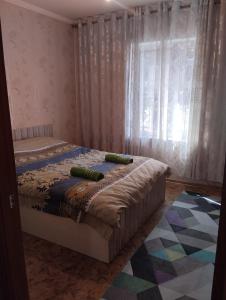 1 dormitorio con 2 camas y ventana en Karakol apartment, en Karakol