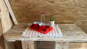 a table with a red tray with cups and a bottle at Malé Milé Áčko in Nižné Malatíny