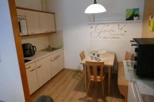 a small kitchen with a small table and a table and chairs at Ferienwohnung Reese- Horstmann mit Hallenbad und Sauna, WLAN "Harz zu jeder Jahreszeit" in Bad Harzburg