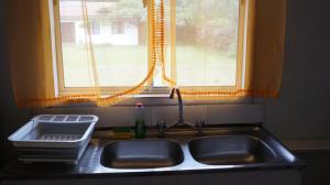 a kitchen sink with a window above it at Cabañas Isla de Pascua in Hanga Roa