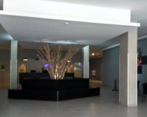 a lobby with a plant in the middle of a building at Itaipava Granja Brasil Studio in Itaipava