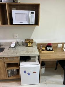 uma cozinha com um balcão e um micro-ondas em Itaipava Granja Brasil Studio em Itaipava
