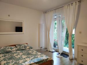a bedroom with a bed and a large window at Kamionka in Sopot