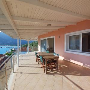 a patio with a wooden table and chairs at Penthouse Vasiliki in Vasiliki