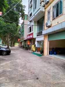 an empty street with a car parked in front of buildings at Căn hộ Sao Mai - Nội Bài Hà Nội in Hanoi