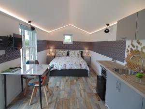 um quarto com uma cama, uma secretária e uma cozinha em The Cabin em Pakenham
