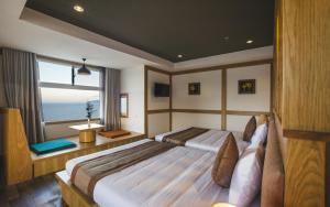 a bedroom with two beds and a large window at Seasing Boutique Hotel in Nha Trang