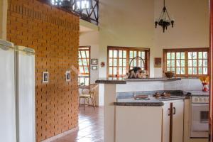 uma cozinha com balcões brancos e uma parede de tijolos em Casa em condomínio com piscina e acesso a represa em Itaí
