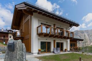 uma casa nas montanhas com uma varanda em Arion Apartments - Trepalle em Livigno