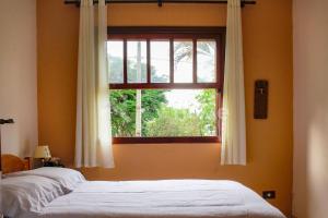 2 camas en una habitación con ventana en Casa em condomínio com piscina e acesso a represa, en Itaí
