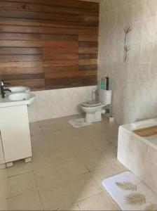 La salle de bains est pourvue de 2 toilettes, d'un lavabo et d'une baignoire. dans l'établissement Espaces Zens&Stimulants grand confort 3ch 3sdb Espaces Jardin Cuisines Sport & Baignade, à Cayenne