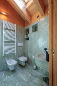 La salle de bains est pourvue de toilettes, d'un lavabo et d'une baignoire. dans l'établissement REVO Apartments - Santa Barbara1, à Bormio
