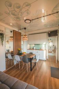 a kitchen and dining room with a table and chairs at RResort - nowe KLIMATYZOWANE domki z PODGRZEWANYM Basenem, Sauna, WiFi, parking w cenie! in Rewal