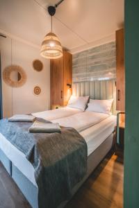 Un dormitorio con una cama grande y una lámpara de araña. en RResort - nowe KLIMATYZOWANE domki z PODGRZEWANYM Basenem, Sauna, WiFi, parking w cenie! en Rewal